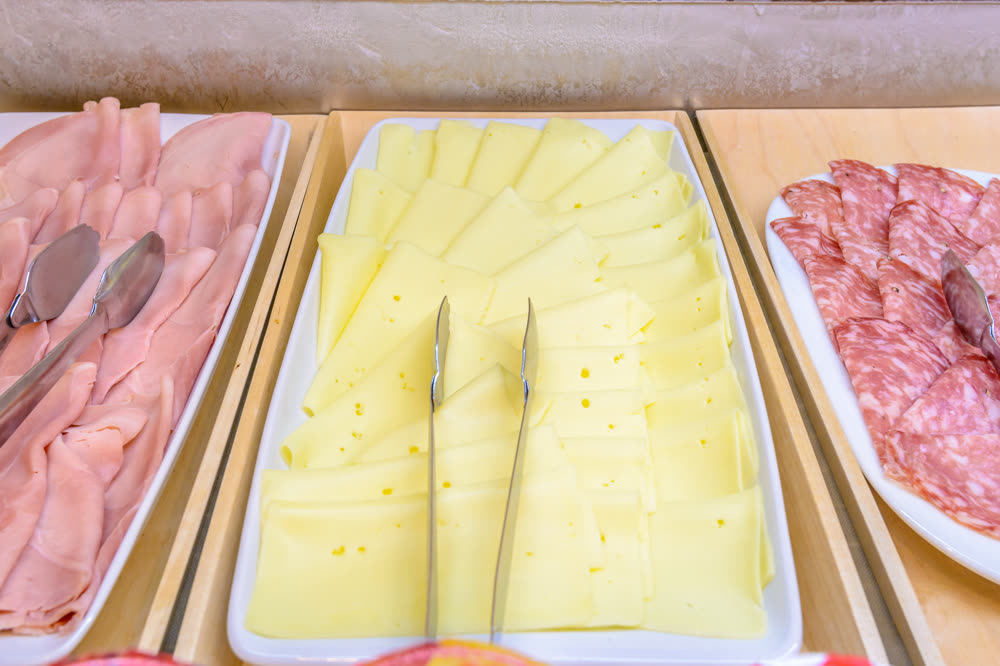 Buffet trays of sliced ham, Swiss cheese and salami